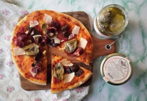 Vista de pizza alcachofas y boletus con ración cortada