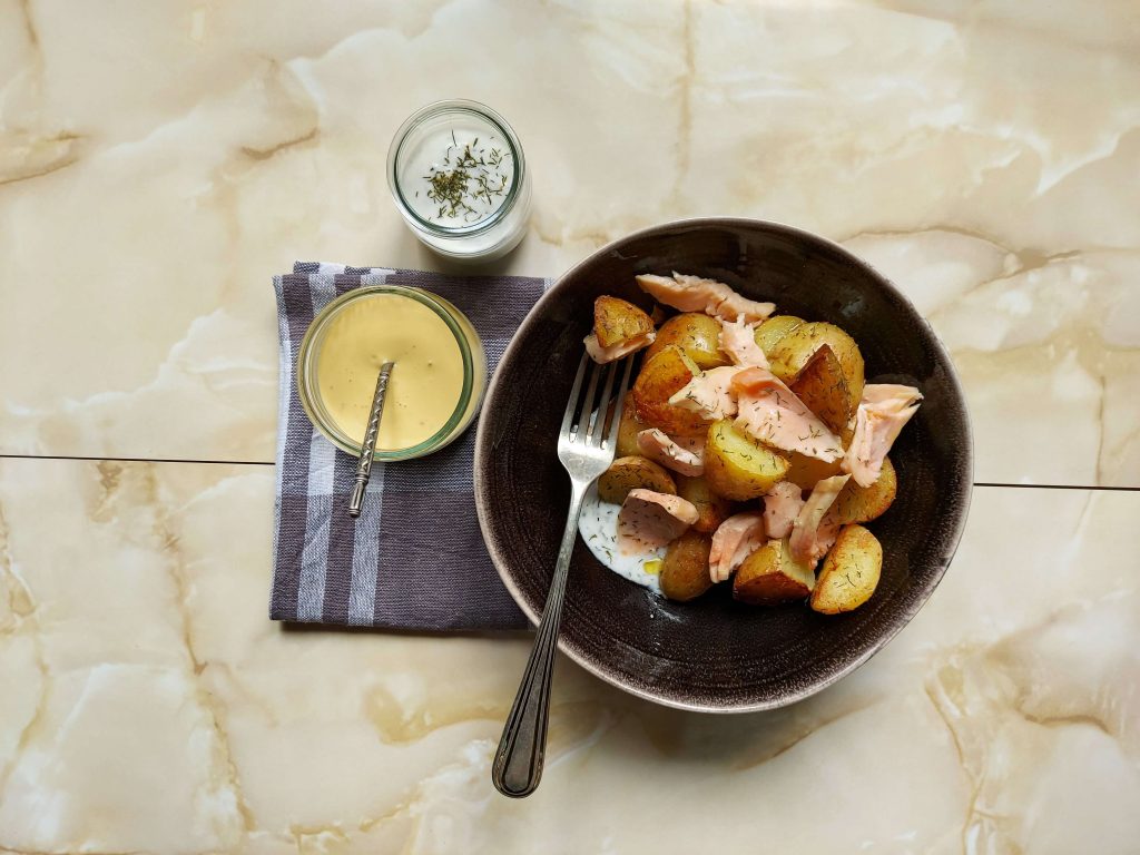 Plato patatas con salmón, salsas y tenedor